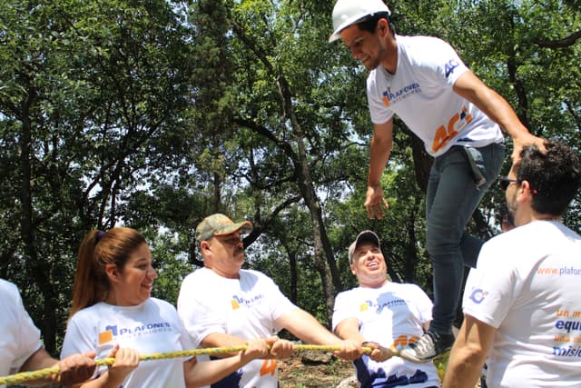 Integrantes trabajando juntos para superar un reto de equilibrio, destacando la importancia de la comunicación efectiva