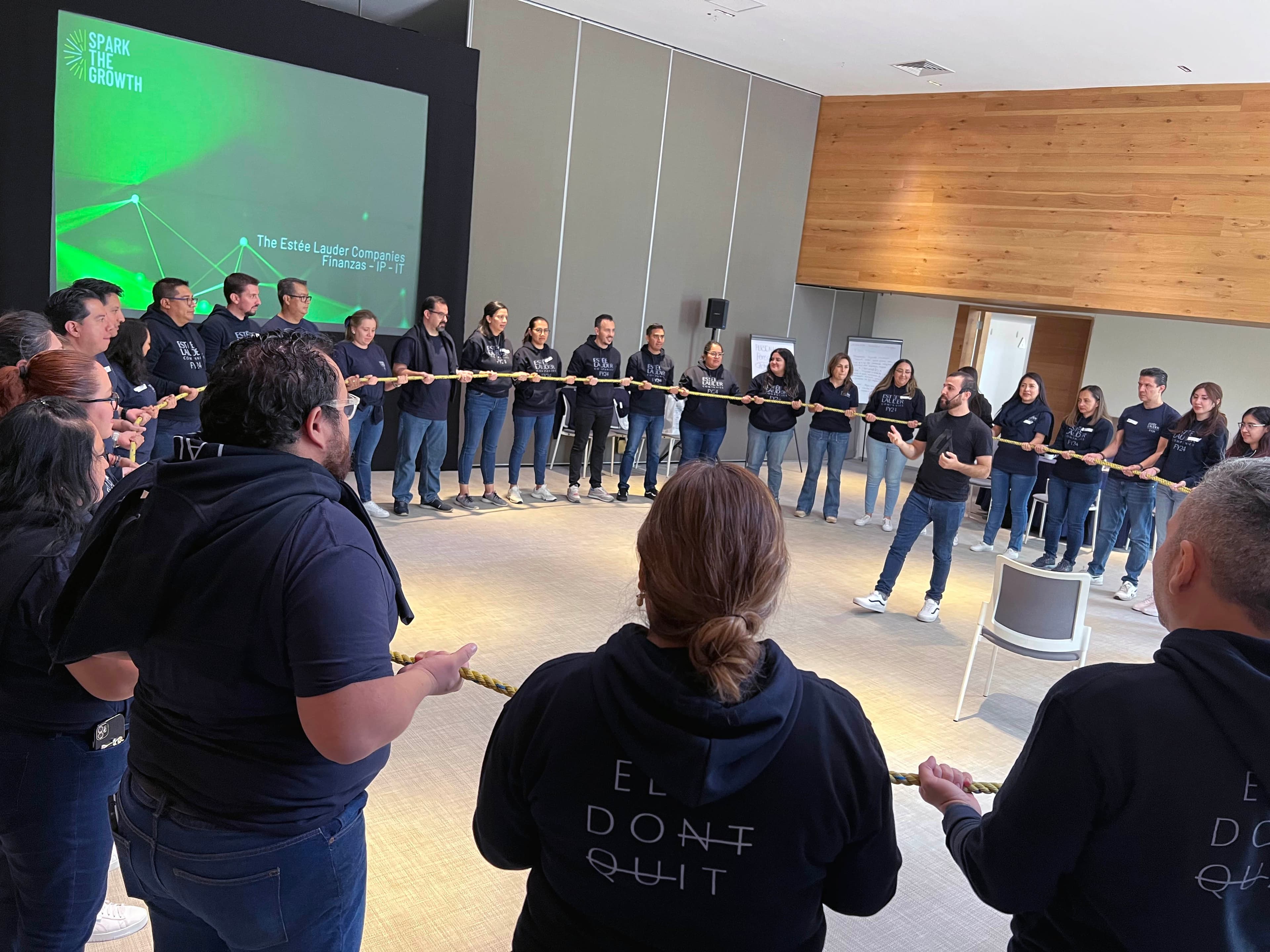 Grupo reunido en una presentación en interiores, aprendiendo conceptos clave para mejorar el trabajo en equipo