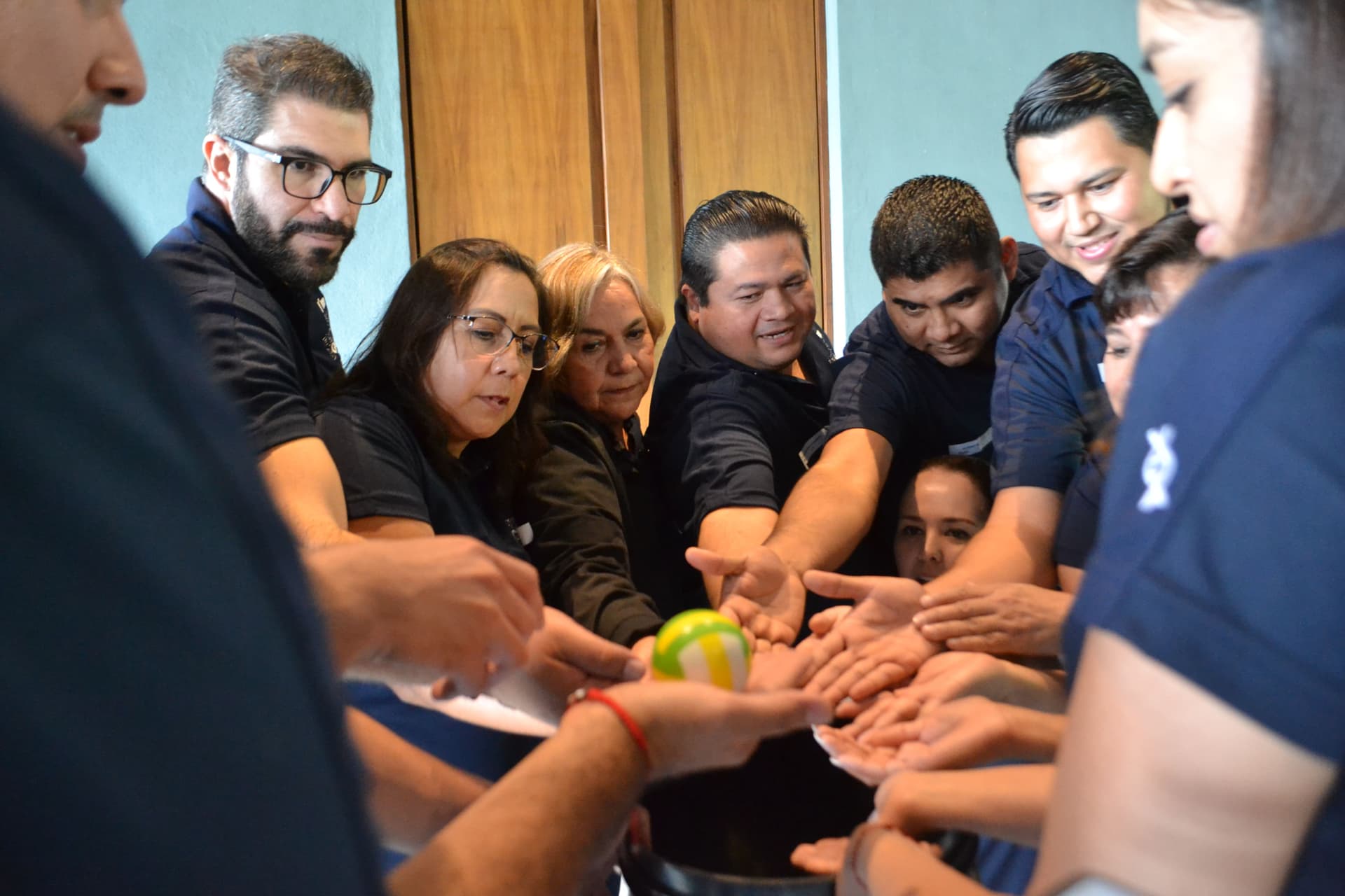 Equipo uniendo fuerzas para completar un desafío práctico, reforzando los valores de colaboración y confianza