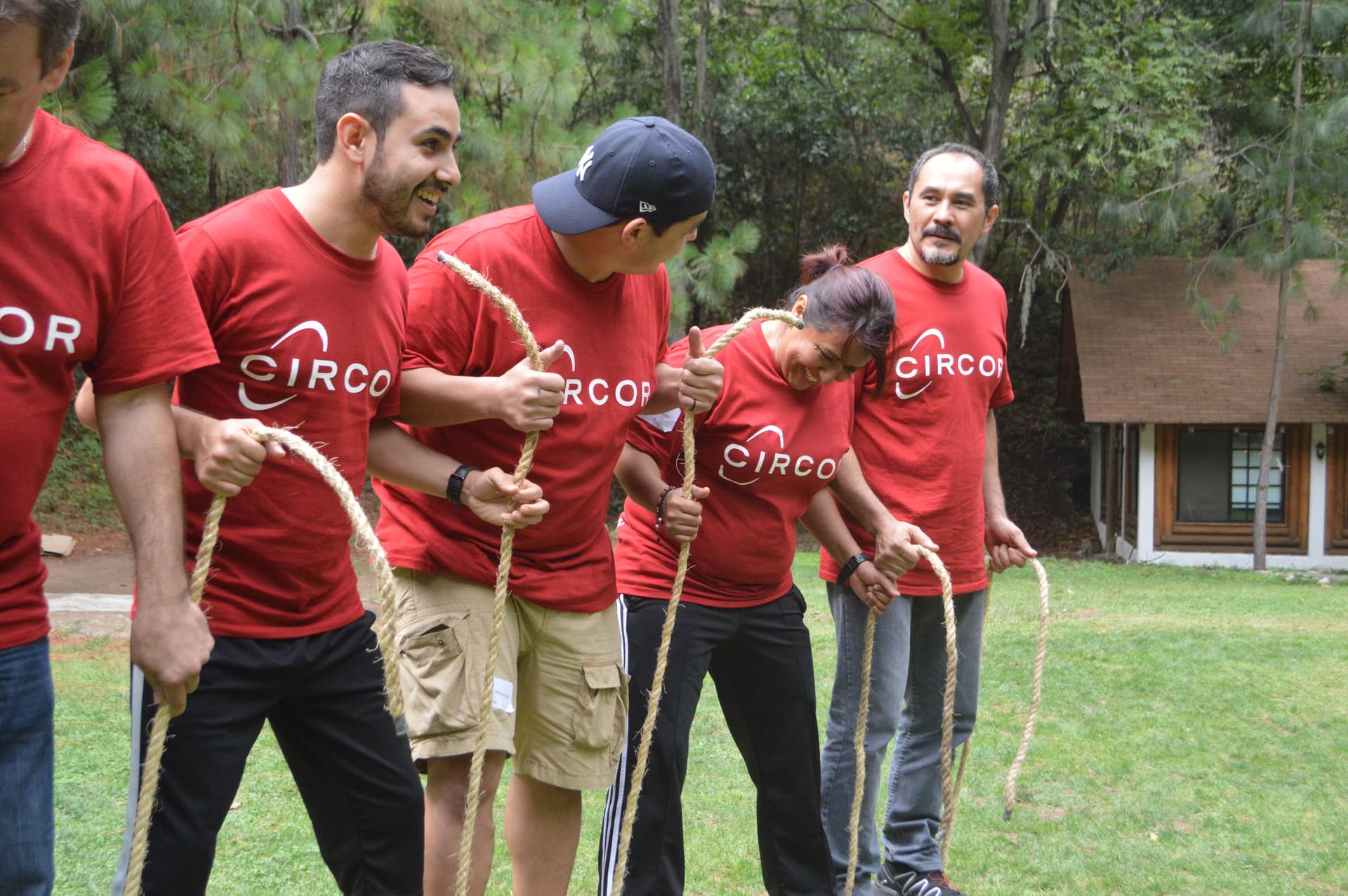 Participantes vestidos de rojo colaborando en una actividad grupal, mostrando el impacto del trabajo en equipo