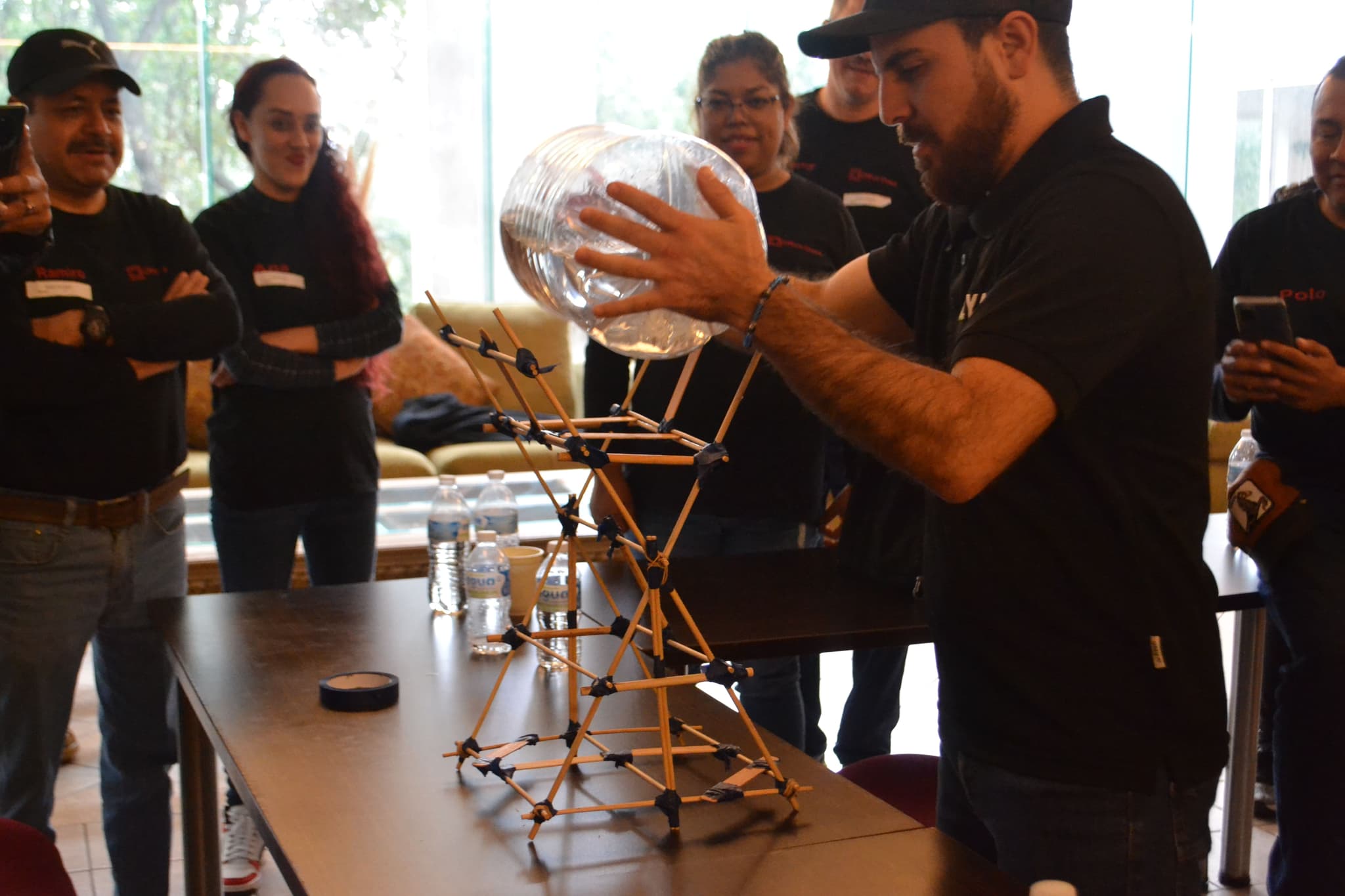 Dinámica en interiores donde los participantes ensamblan estructuras, demostrando creatividad y cooperación en Team Building